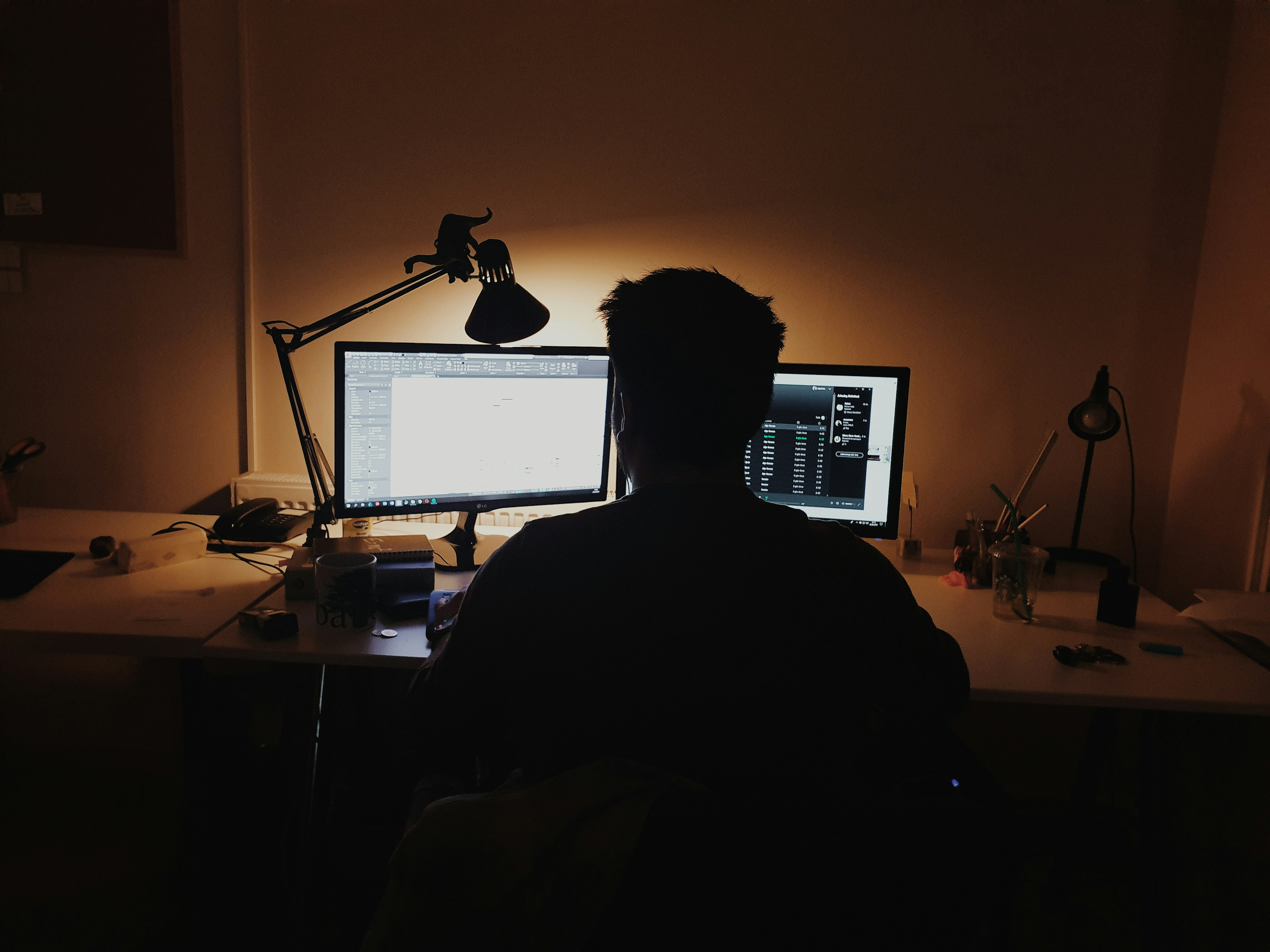 Developer working at a dual-monitor desk setup